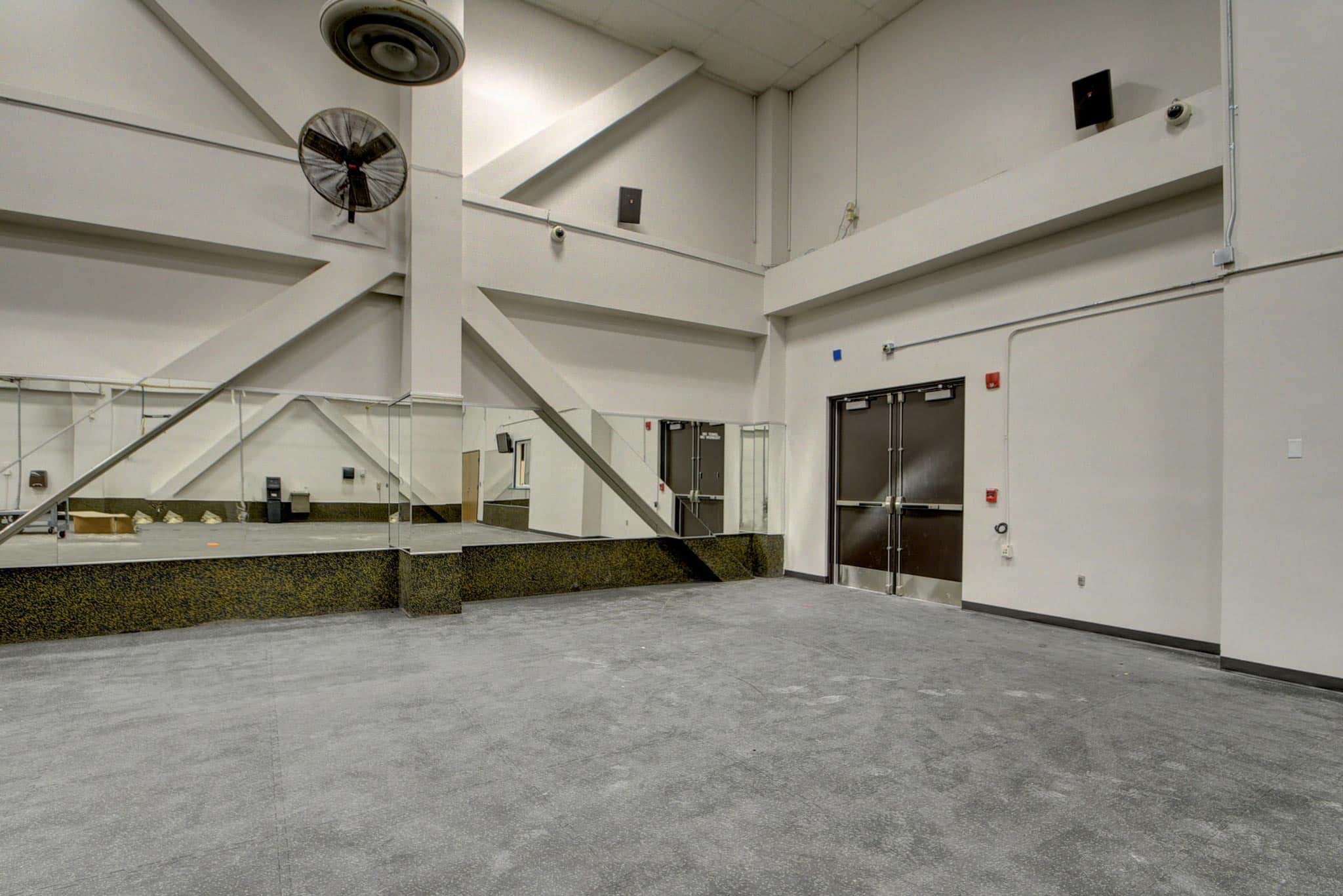 Garage area with concrete vinyl flooring at the Palm Beach Sheriff's Office next to mirrored walls.